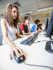 Teenage Students: Computer Skills. A female pupil working in her college computer suite. From a series of high school education related images.