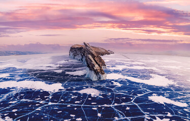 Beautiful landscape island Ogoy winter lake Baikal with transparent cracked blue ice, sunset aerial top view. Concept travel Russia