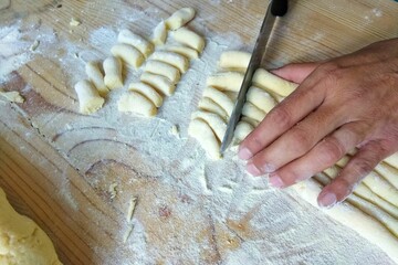 Wall Mural - Mans hand cutting a dough