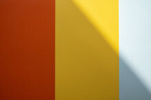 Background Of Red, Yellow And Gray Colors With A Shadow. Colored Vertical Stripes Of Different Widths. Copy Space. 