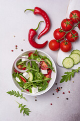 Wall Mural - Healthy vegetarian salad with fresh arugula, cherry tomatoes, soft cheese and cucumbers