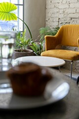 Wall Mural - Vertical shot of a room interior with a blurry muffin in the foreground