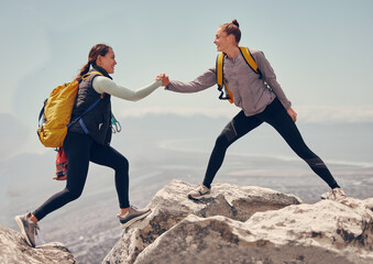 Poster - Happy women help while hiking up a rocky mountain in nature with backpack. Females friends exercise in nature park climbing and jumping while with sportswear training or trekking together outdoors