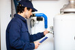 © Minerva Studio - Smiling technician repairing an hot-water heater