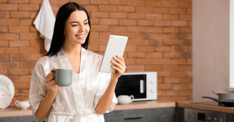 Poster - Morning of beautiful young woman with tablet computer and coffee in kitchen