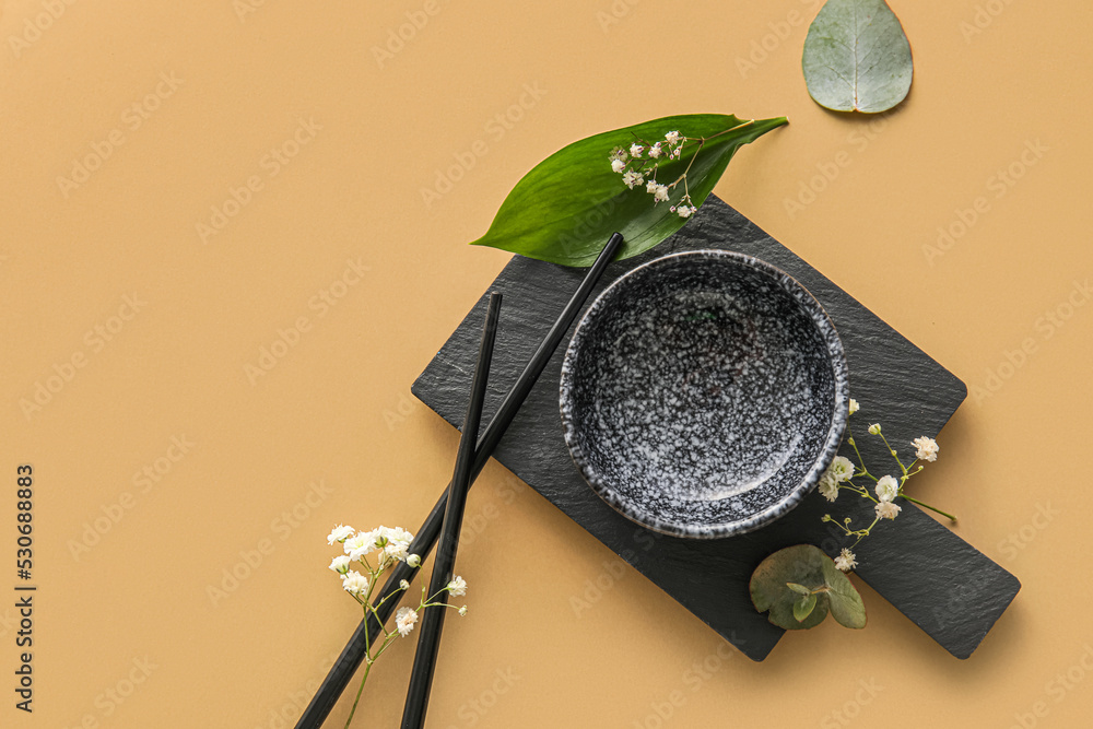 Table setting with chopsticks and gypsophila flowers on beige background