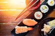 Sushi Set nigiri shrimp and salmon and sushi california rolls with avocado and maki, on wood,