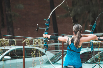 o antigo esporte de arco e flecha com uma mulher treinando a pontaria para acertar o alvo e disparando a flecha com toda técnica envolvendo posicionamento e concentração