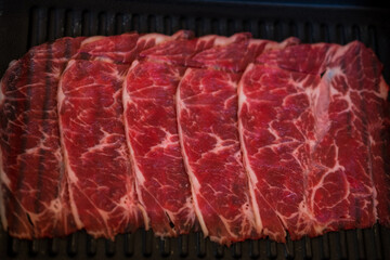 Wall Mural - Thinly sliced of raw beef on tray prepare for customer cook. Japanese hot pot also known as Shabu Shabu or Sukiyaki is Japanese style is popular local food in asian countries.