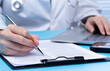 © Jade - Professional Doctor sign Health care medical document of patient medicine in hospital office. Doctor wear lab coat uniform read patient chart on desk for insurance person and note pen, copy space