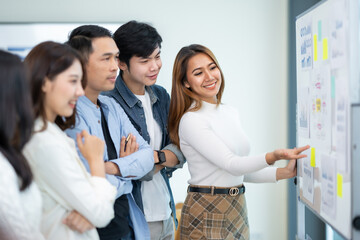 Wall Mural - Group of young Asian businesspeople brainstorming meeting to discuss planning strategies new business development working on a new startup project in the office.