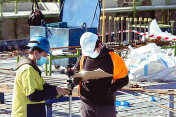 Wall Mural - surveyors marking up a construction deck with face masks
