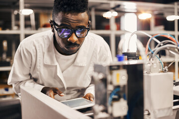 Wall Mural - african engineer programming equipment with tablet at factory