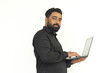 © NIKHIL - Selective focus of Indian young businessman standing, holding laptop .Isolated over white background.