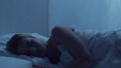Young woman lying in the bed at night. Beautiful blond sleeping girl. Twilight in the bedroom, moonlight from the window. Health and rest concept.