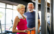 © NDABCREATIVITY - Senior fit man and woman doing exercises in gym to stay healthy