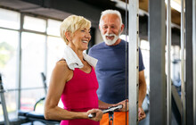 Senior Fit Man And Woman Doing Exercises In Gym To Stay Healthy