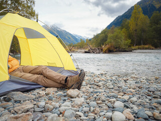 Wall Mural - trip to Caucasus mountains, Arkhyz, Teberdinsky reserve. Man traveler relaxing mountains and river in tent camping outdoor Travel adventure lifestyle concept hiking active vacations.