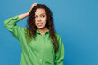 Young minded confused mistaken sad woman of African American ethnicity 20s she wear green shirt look aside hold scratch head isolated on plain blue background studio portrait People lifestyle concept
