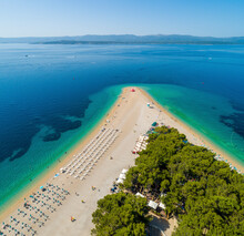 Aerial View Of Sunbeds Lined Up On Beach On Zlatni Rat In Bol On The Island Of Brac, Croatia.