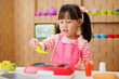 young girl pretend playing food preparing at home