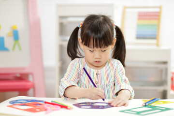 Wall Mural - young girl practice drawing different shapes  for homeschooling