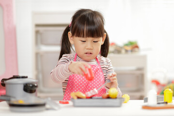 Wall Mural - young  girl pretend play food preparing at home