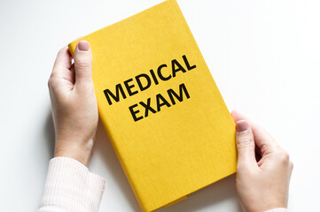 Wall Mural - Medical exam text on the yellow cover of a magazine in the hands of a person
