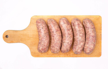 Wall Mural - Raw white sausages on a wooden cutting board, isolated. Polish meat product, Easter delicacy. A packshot photo.