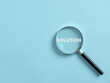 Leinwandbild Motiv Magnifier focuses on the word solution. Searching for a business solution concept.