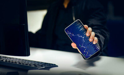 Hands of a businessman working with a smartphone Technical price charts and indicators and mobile screen background for stock trading