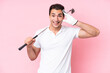 Young golfer player man isolated on pink background with surprise expression