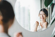 © Daenin - Asian woman looking through the mirror and confident of herself. cheer yourself up