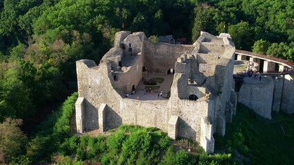 Wall Mural - Aerial drone view of the Neamt Citadel in Targu Neamt, Romania. Fortress with tourists on the top of a hill, surrounded by lush forest