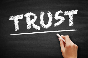 TRUST - firm belief in the reliability, truth, or ability of someone or something, text concept on blackboard