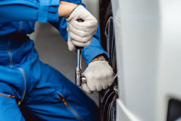 Canvas Print - Automotive mechanics repairman use a socket wrench to replace the spare wheel, check the mileage of the car, check tire pressure, auto maintenance service concept.