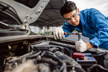 Wall Mural - Auto mechanic repairman using a socket wrench working engine repair in the garage, change spare part, check the mileage of the car, checking and maintenance service concept.