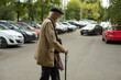 © Олег Копьёв - Old man walks through parking lot. Old man with stick. Man in poor clothes. Retired in Russia.