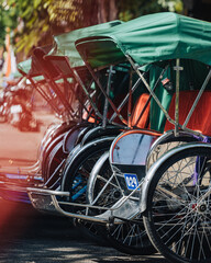 Hoi An, Vietnam - July 29th, 2022 : a row of rickshaws on the streets of Hoi An