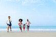 © CandyRetriever  - African family on beach holiday vacation. Father and mother with little daughter and son playing together on the beach at summer sunset. Parents with kid enjoy outdoor lifestyle together at the sea