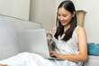 © CandyRetriever  - Young Asian woman playing with her tabby cat while working on laptop computer on couch in living room. Happy girl enjoy indoor lifestyle with kitten cat at home. Pets owner relationship concept.