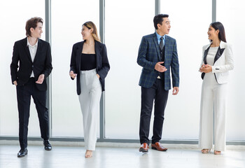 Full body shot of Millennial Asian successful professional male businessmen and female businesswomen in formal suit smiling posing look at camera walking side by side together in company hallway