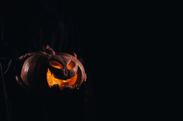 Wall Mural - The witch is holding a pumpkin jack o lantern glowing in the dark. Halloween.