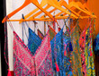 Set of beautiful women's dresses of different colors displayed on hangers for sale in the street