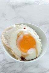 Wall Mural - Sunny side up fried egg on rice with soy sauce for Asian breakfast food