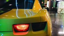 Sports Car Taillight Movie Hero Yellow. High Quality 4k Footage. Exhibition Tuning Garage Power Stand Booster Spoiler