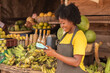 african lady in a market using a pos device