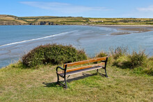 Newport, Pembrokeshire, Wales - August 2022: Wooden Bench On The Edge Of A Cliff Overlooking Newport Sands