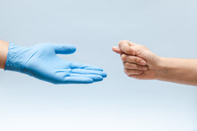 Hand Shows A Fig Sign To A Hand In Blue Glove: Doctor Or Nurse. Corruption