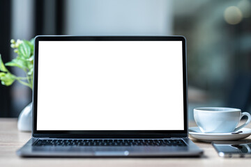 Wall Mural - Mockup of laptop computer with empty screen with coffee cup and smartphone on table of the coffee shop background,White screen